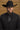 man wearing black suit with black accessories styles with a black cowboy hat