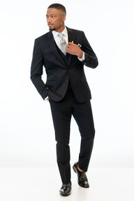 man wearing Black Performance Stretch suit, white shirt, silver tie, and black loafers