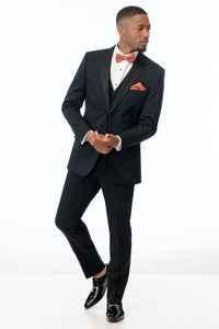 Man wearing Black Performance Stretch Tuxedo with a sedona colored bow tie on a white background