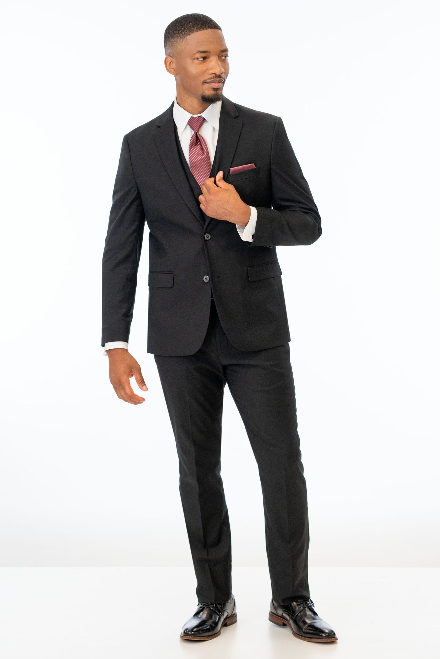 Man wearing Black Stretch Suit with a white shirt and rosewood striped tie on a white background