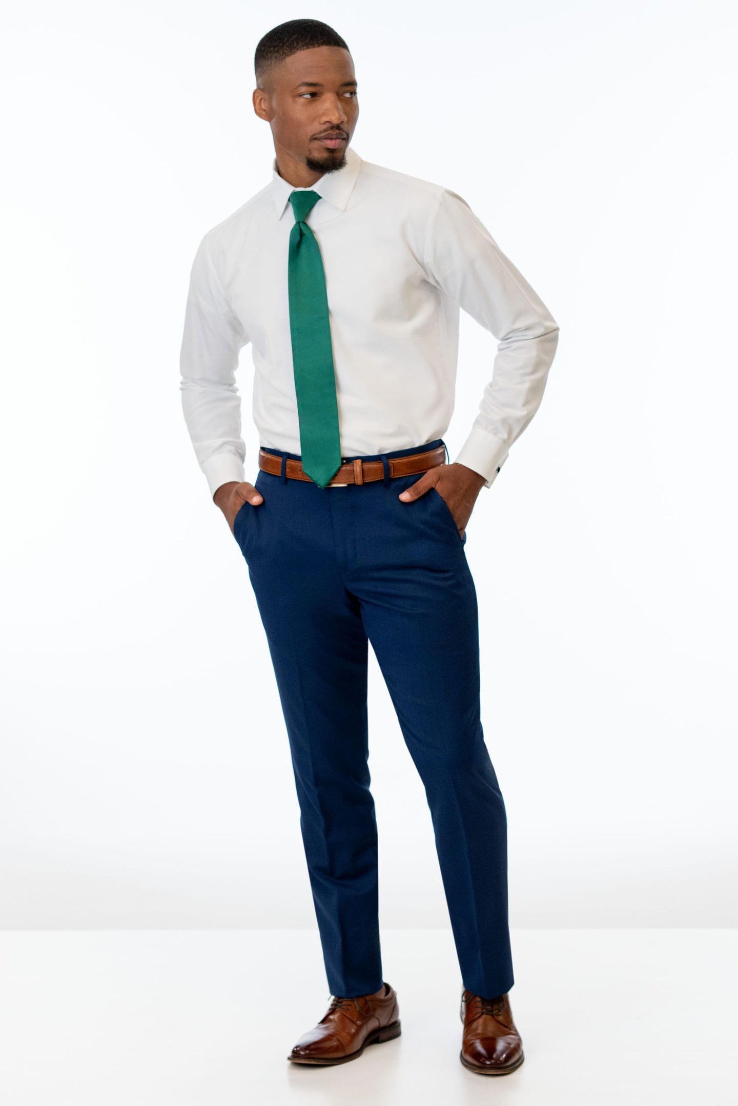 man wearing Blue Performance Stretch Slim Fit Suit pants, white shirt, and emerald green tie