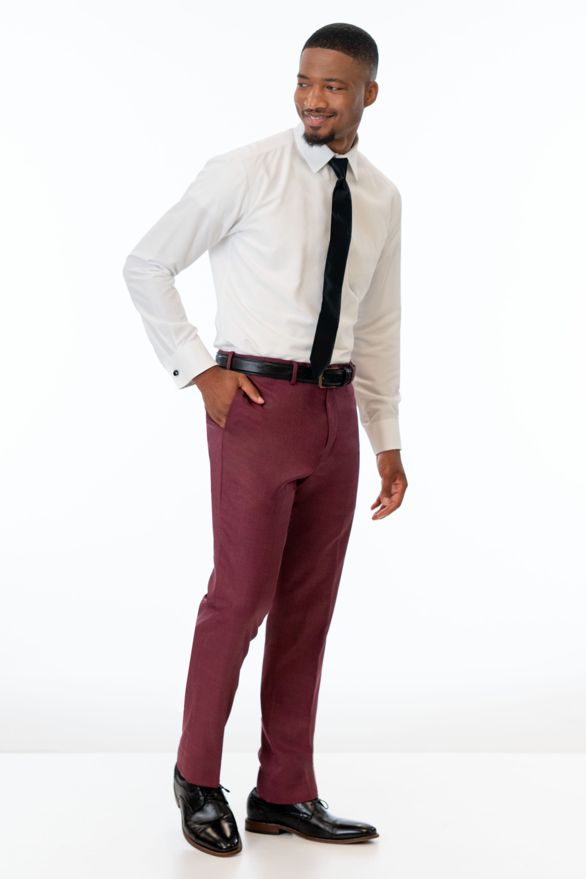 side view of man wearing Brick Stretch Slim Fit Suit pants, white shirt, and black tie