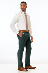 side view of man wearing Dark Green Stretch Slim Fit Suit pants, white shirt, and pink tie
