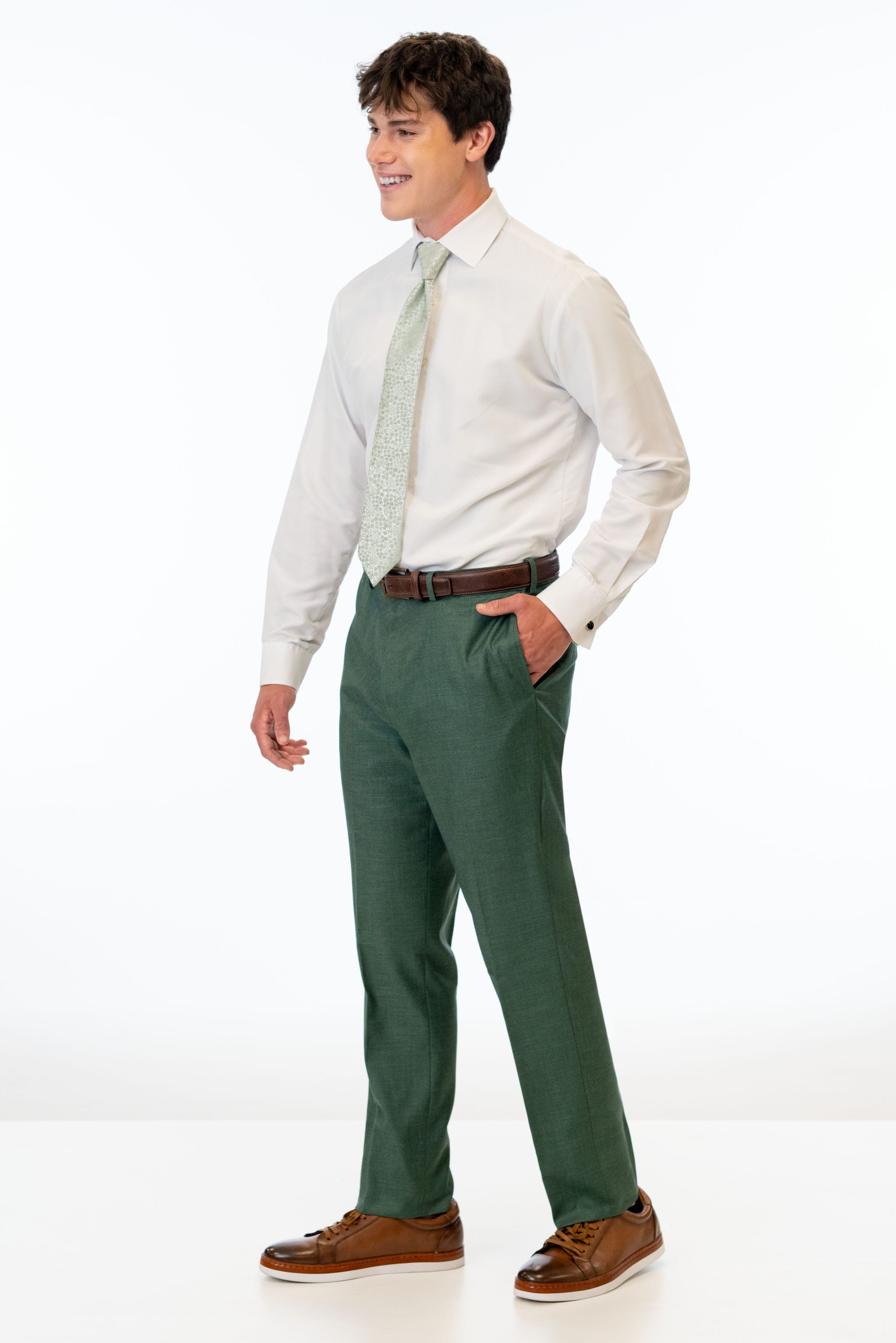 side view of man wearing Forest Green Stretch Slim Fit Suit pants, white shirt, and floral green tie