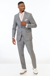 Man wearing Heather Grey Clayton suit with a white shirt and white shoes on a white background