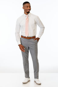 Man wearing Heather Grey Clayton pants with a white shirt and pink tie on a white background