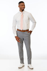 Man wearing Heather Grey Clayton pants with a white shirt and pink tie on a white background