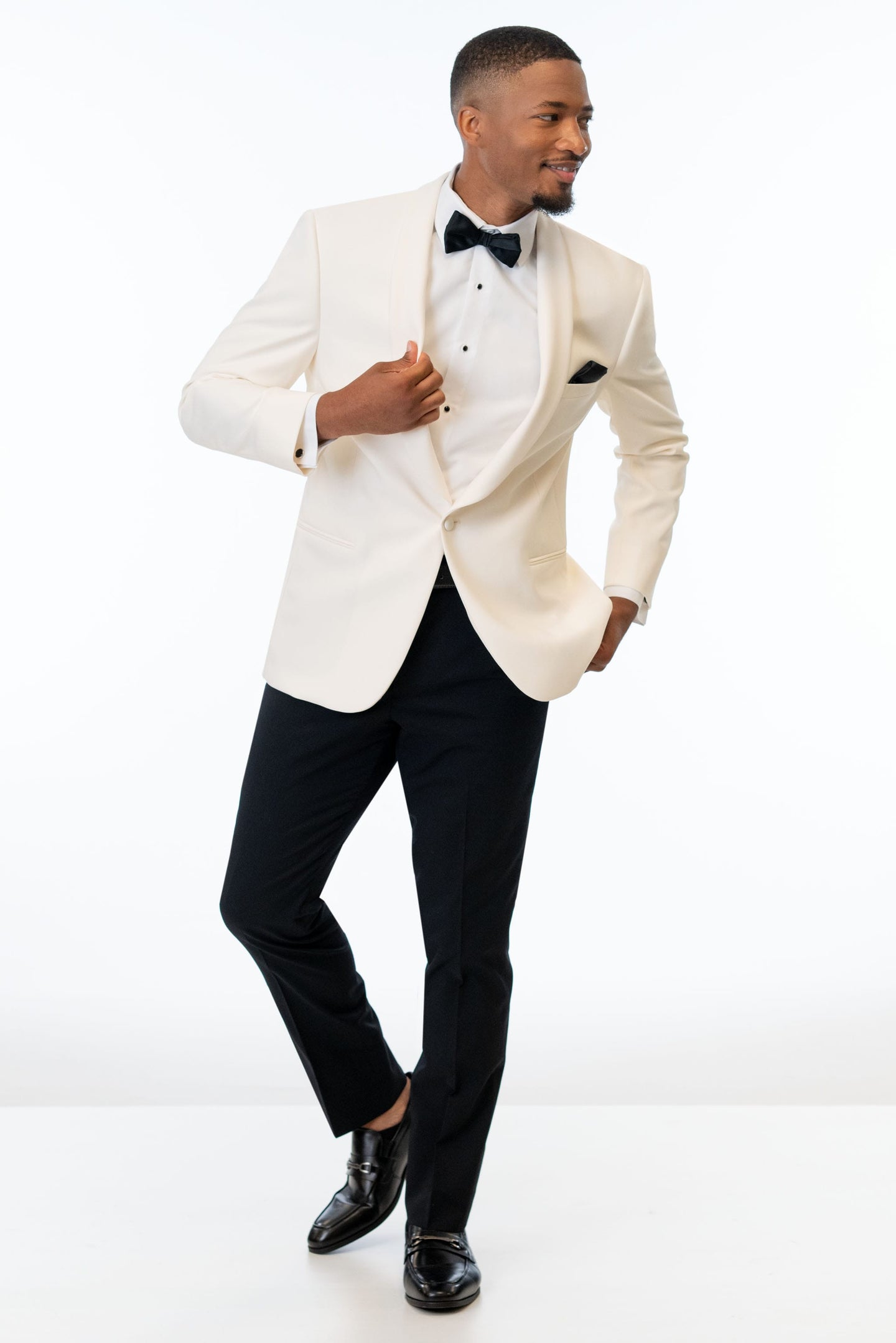 Man wearing the Ivory Dinner Jacket with black pants and bow tie on a white background