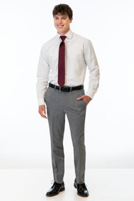 Man wearing a white dress shirt, Medium Grey Performance Stretch pants, black shoes, and a red tie on a white background