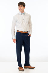 side view of man wearing Navy Sterling Slim Fit Suit pants, white shirt, and light blue bow tie