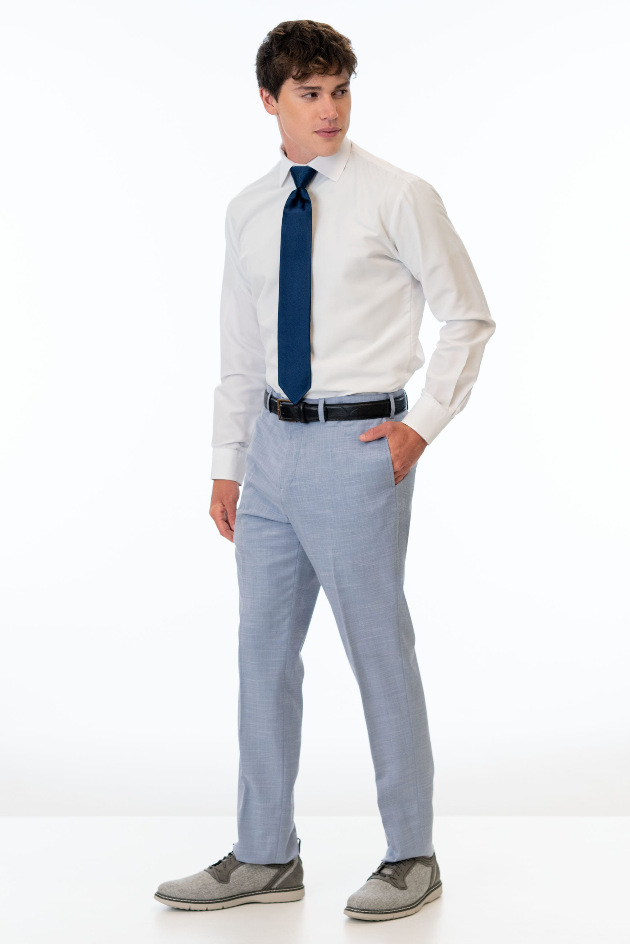 side view of man wearing Oxford Blue Stretch Slim Fit Suit pants, white shirt, and navy blue tie