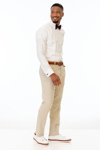 side view of man wearing Tan Stretch Slim Fit Suit pants, white shirt, and bow tie