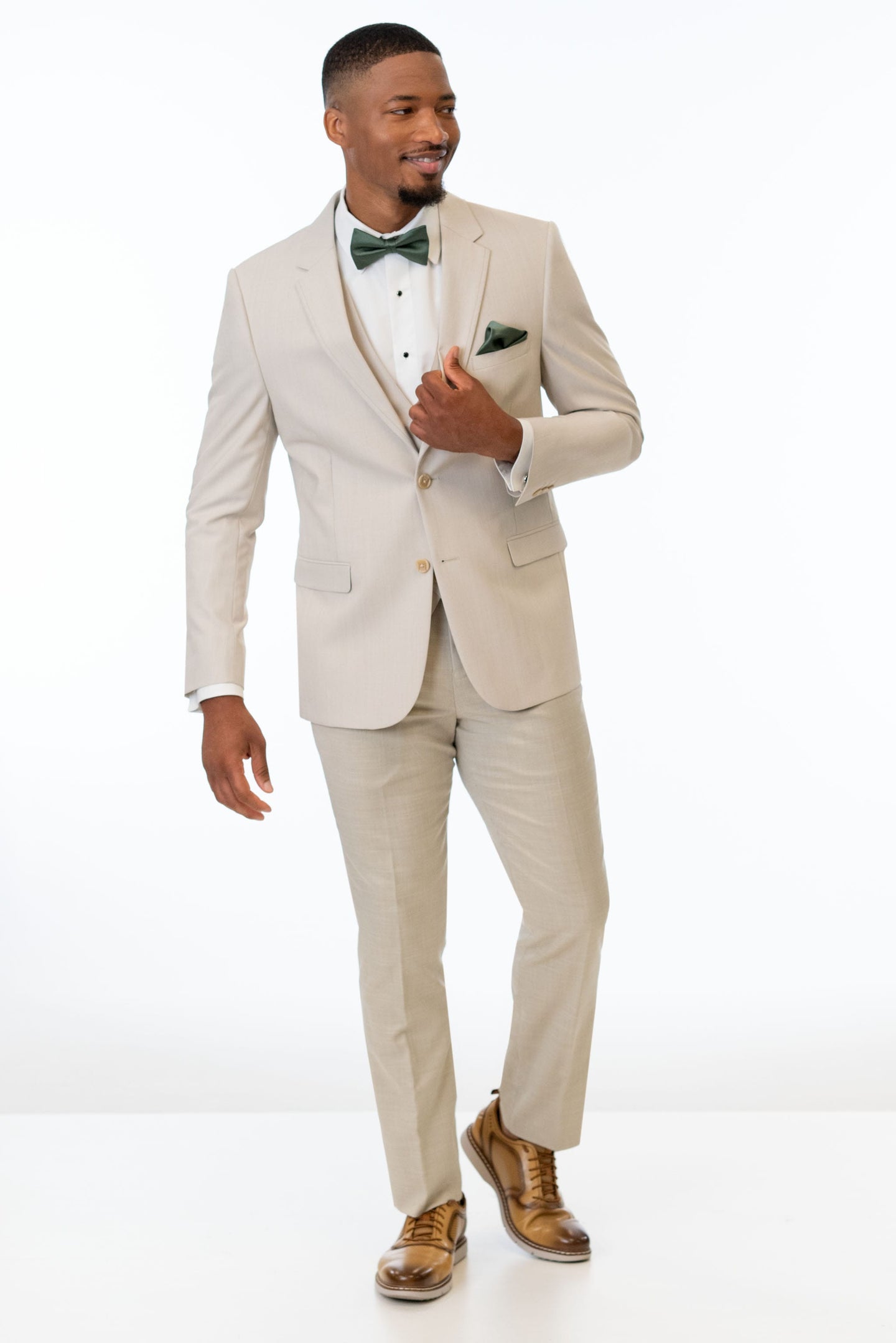 man wearing Tan Performance Stretch suit, white shirt, and green bow tie