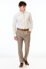 man wearing Wheat Stretch Slim Fit Suit pants, white shirt, and ivory tie