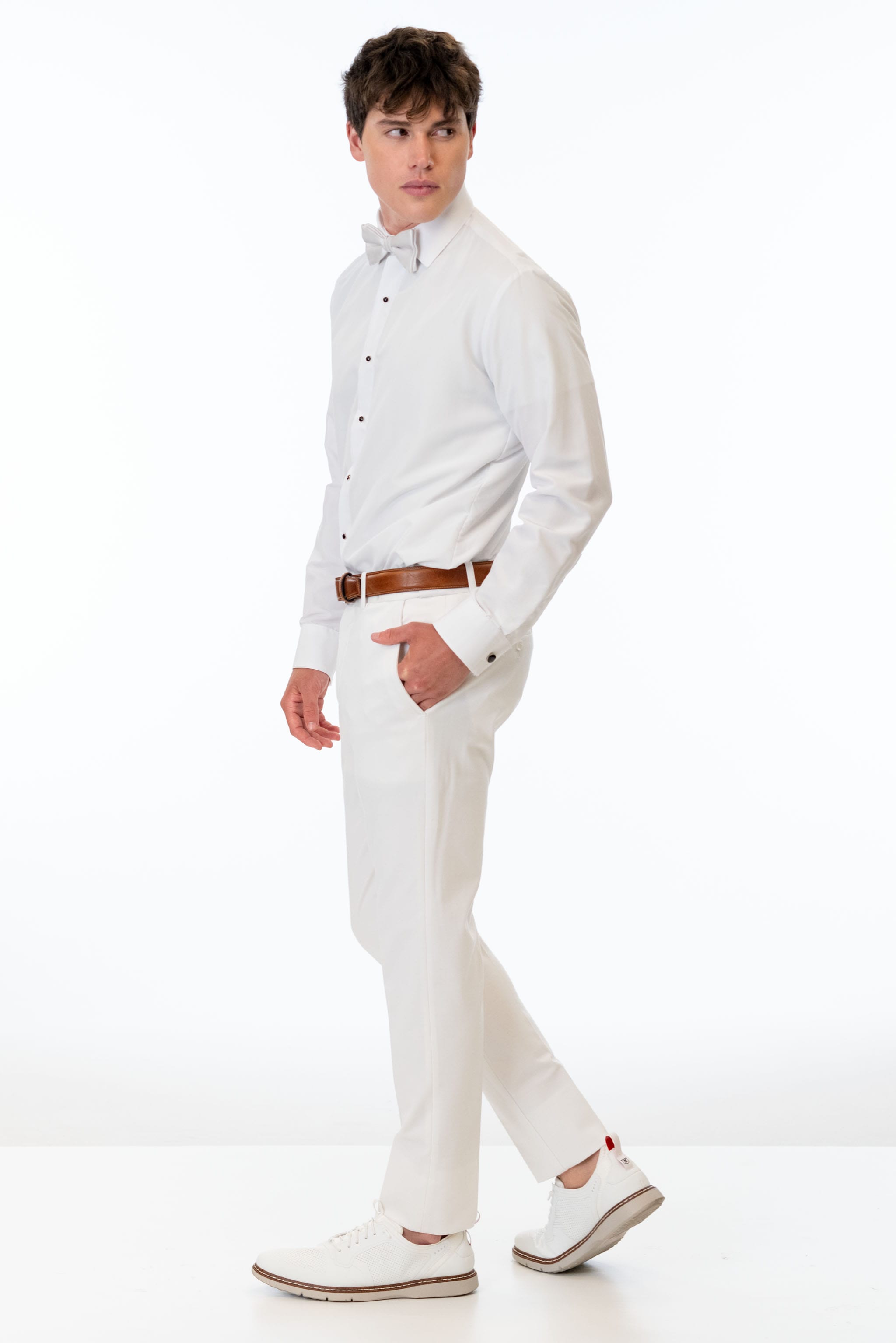 side view of man wearing White Euro Slim Fit Suit pants, white shirt, and bow tie