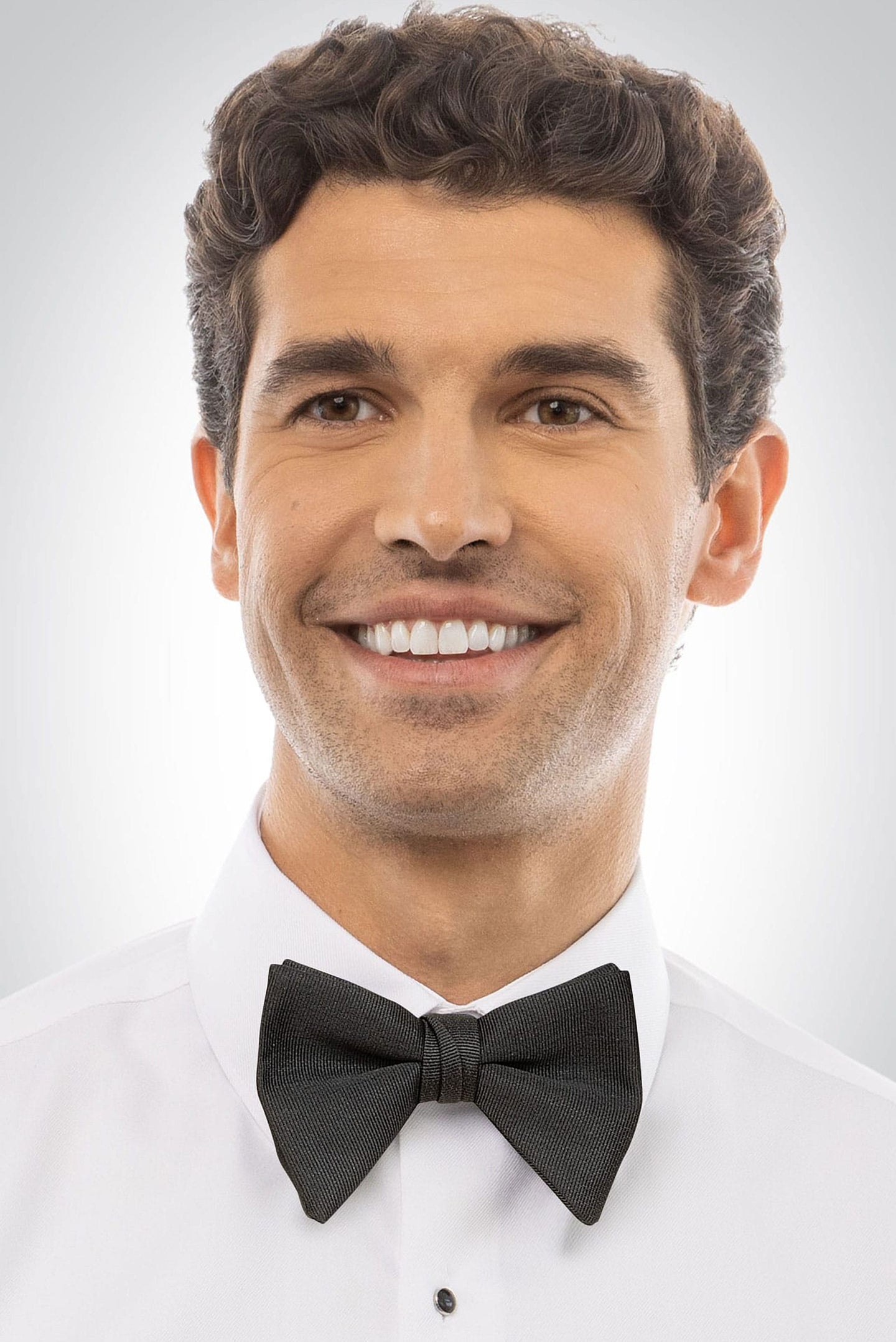 Man wearing a black pre-tied faille bow tie and white shirt 