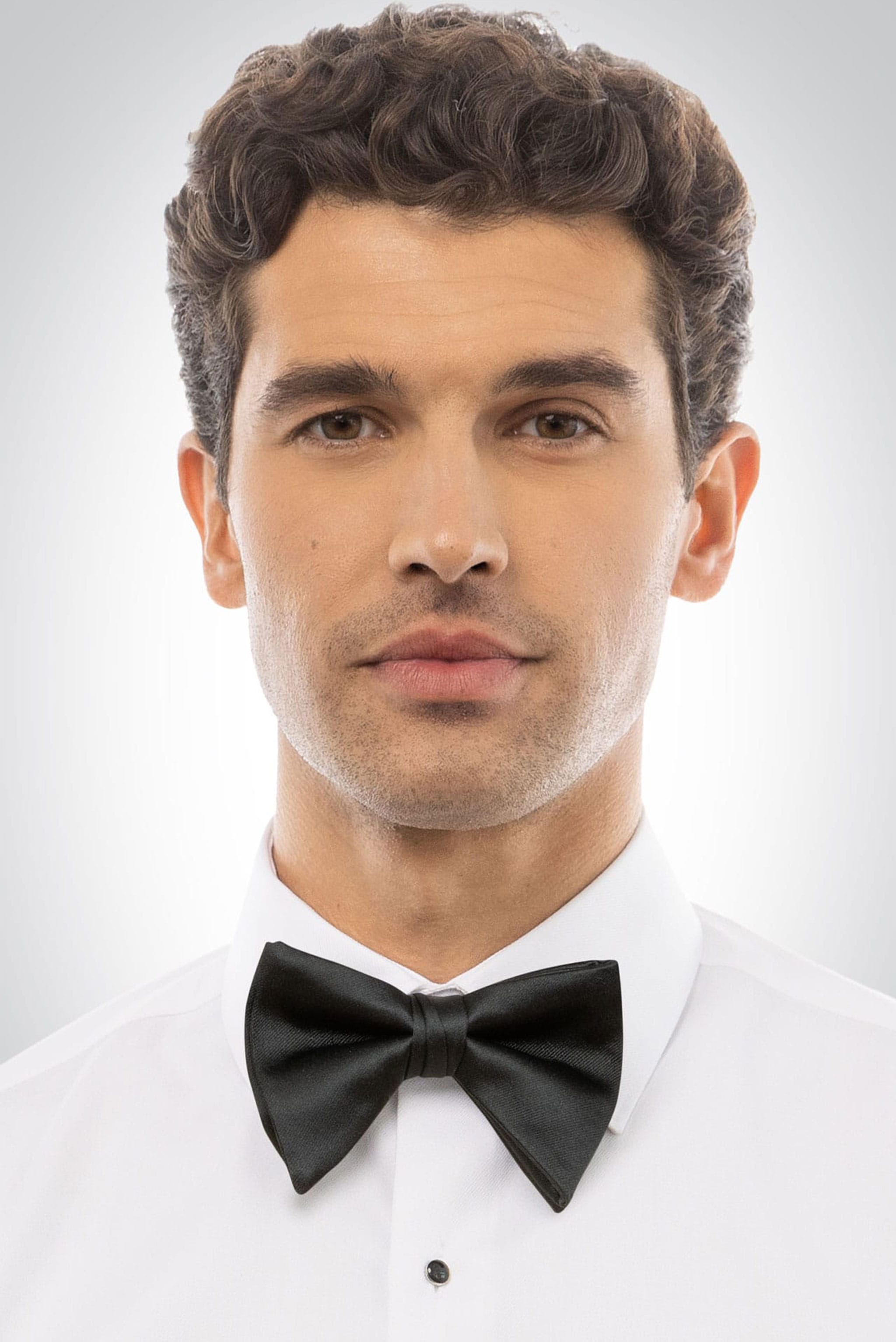 Man wearing a black satin tear drop bow tie and white shirt 