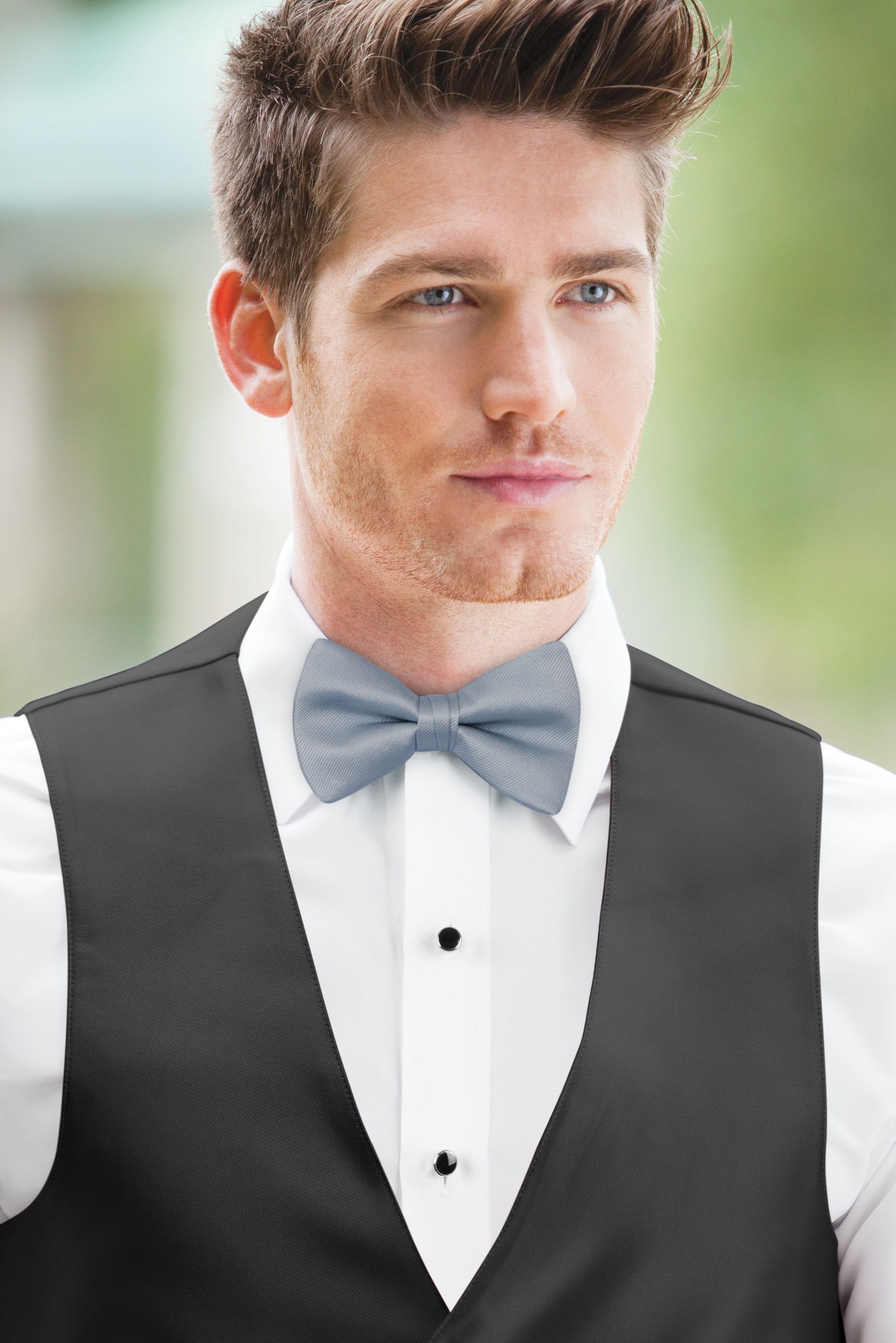 man wearing white shirt, solid dusty blue bow tie, and matching Expressions vest