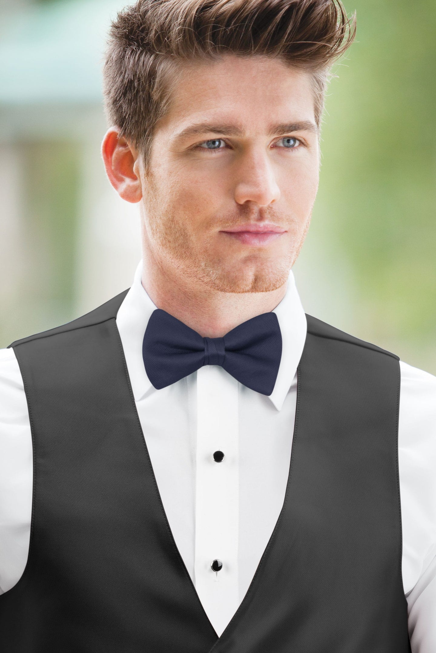 man wearing white shirt, solid marine bow tie, and matching Expressions vest