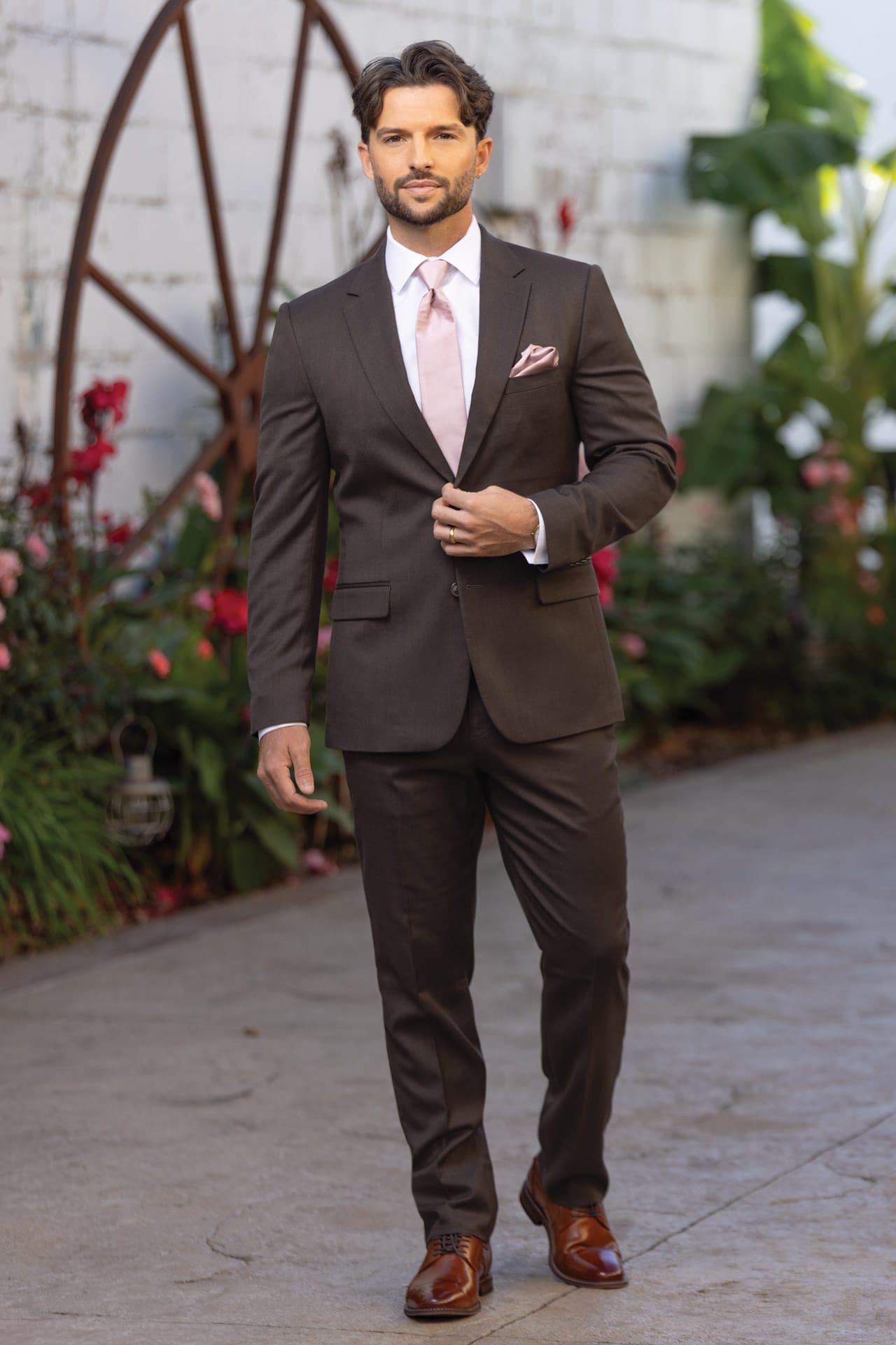 Man wearing Dark Brown Stretch Slim Fit Suit coat and pant with a white shirt and light pink tie.