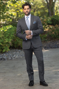man wearing slate grey stretch slim fit suit coat, pant, and vest with white shirt and light blue windsor tie