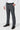 Person wearing slate grey dress pants with a white shirt and black shoes on a white background