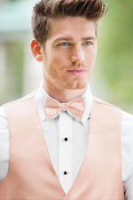 man wearing white shirt, solid blush bow tie, and matching Expressions vest