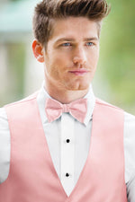 man wearing white shirt, solid rose petal bow tie, and matching Expressions vest