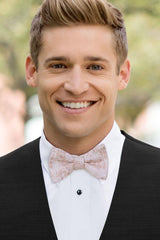 man wearing white shirt, floral blush bow tie and solid black Expressions vest