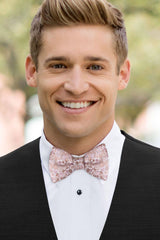 man wearing white shirt, floral rose gold bow tie and solid black Expressions vest