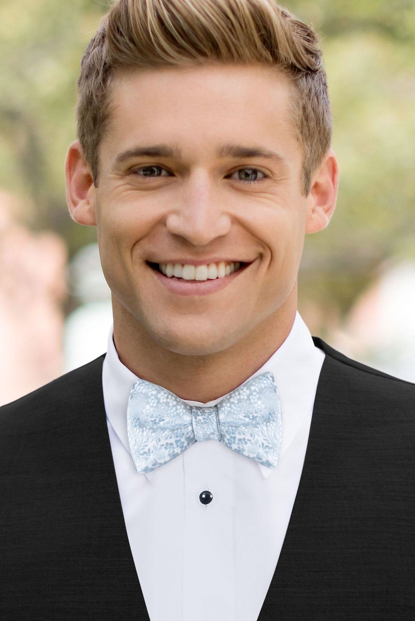 man wearing white shirt, floral sky blue bow tie and solid black Expressions vest