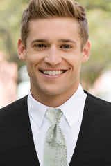 man wearing white shirt, floral sage windsor tie and solid black Expressions vest